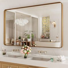 a bathroom with two sinks and a large mirror on the wall over it's sink