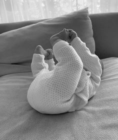 a woman laying on top of a bed next to a window