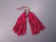 Hand beaded by me, with a berry red color mix of glass seed beads; these tassel earrings have copper flower bead caps, and french hook ear wires. Purples, reds, pinks, and citrine colors to brighten your day! These earrings measure just over two and 1/4 inches in length See more of my designs here; justEARRINGS.etsy.com More Beaded Tassel earrings here: https://www.etsy.com/shop/justearrings?search_query=tassel+glass+cone And please visit my sister~shops; justCHARMING.etsy.com & BohoDreamJewelry Red Beaded Earrings With Tassels, Red Beaded Earrings With Tassels And Round Beads, Red Beaded Fringe Tassel Earrings With Round Beads, Red Tassel Earrings With Round Beads As Gift, Red Tassel Beaded Earrings, Red Fringe Tassel Earrings With Round Beads, Elegant Red Tassel Earrings With Fringe, Red Tassel Earrings With Dangling Round Beads, Beaded Fringe Earrings