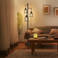 a living room with a couch, table and two lamps on the wall next to it