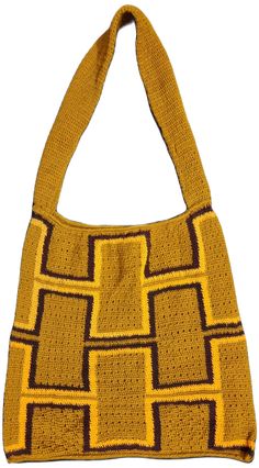 a crocheted yellow and brown bag with squares on the front, sitting on a white surface