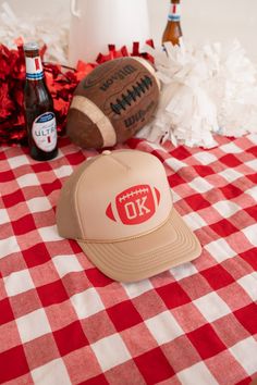 a hat sitting on top of a red and white checkered table cloth next to bottles