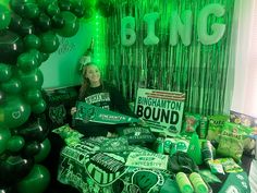 a woman holding up signs in front of green balloons