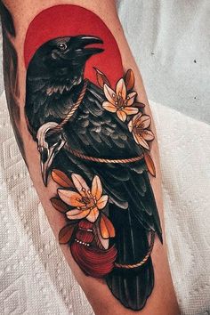 a black bird sitting on top of a red circle with flowers in it's beak