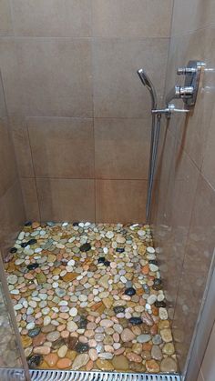 there is a shower with pebbles on the floor