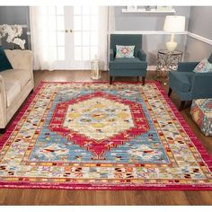 a living room filled with furniture and a rug on top of a hard wood floor