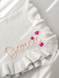 a white shirt with pink flowers and the word grace embroidered on it's chest