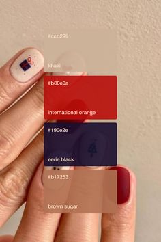 a woman's hand with red, white and blue nail polishes on it