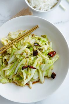 a white plate topped with lettuce and chopsticks