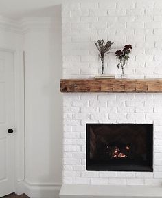 a white brick fireplace with some flowers on top