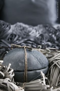 a rock wrapped in twine on top of a bed