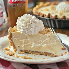 a piece of pie on a plate with a fork and ice cream in the background