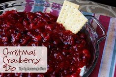 christmas cranberry dip in a glass bowl with crackers on the side and text overlay that reads, christmas cranberry dip