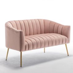 a pink velvet couch with gold legs on an isolated white background in front of a wall