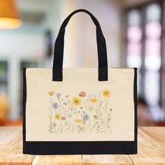 The Wildflower 100% Cotton Tote Bag. This Floral Tote Bag for Women features a captivating wildflower design that will add a splash of nature-inspired beauty to your daily routine. Measuring a generous 17” x 14” x 6”, this eco-friendly reusable bag is crafted from 100% cotton with reinforced stitching, ensuring both durability and elegance. It's roomy enough for beach days, picnics, errands, and everything in between, making it your new go-to bag for all your adventures. Wildflower Design, Craft Tote, Floral Tote Bag, Cotton Tote Bag, Floral Gifts, Reusable Bags, Beach Days, Eco Conscious, Bag For Women