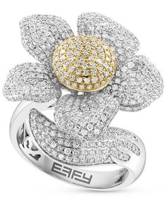 a white and yellow gold ring with flowers on it's center, surrounded by diamonds