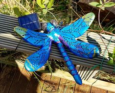 a blue dragon sitting on top of a wooden bench