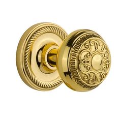 an antique brass door knob with decorative design on the front and side, set in polished brass