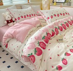 a bed with pink and white strawberry print on it