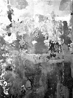 an abstract black and white painting with paint splattered on it