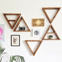 the wall is decorated with wooden shelves and pictures on it, along with a potted plant