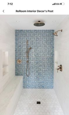 a bathroom with blue and white tile on the walls, shower head, and hand held faucet