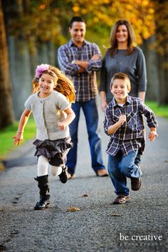 three children running down the road with their parents