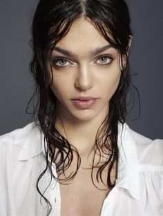 a woman with long hair wearing a white shirt and posing for a magazine cover photo