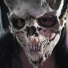 a woman wearing a creepy mask with horns