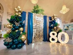 an elaborately decorated room with blue and gold balloons in the shape of numbers 80