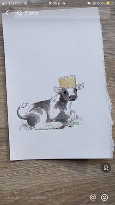 a drawing of a cow with a piece of paper on it's head sitting on a table