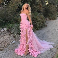 a woman in a pink dress posing for the camera