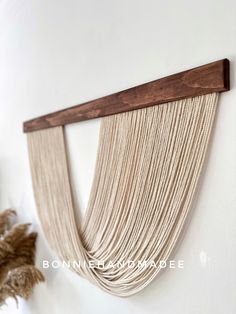 the wall hanging is made out of wood and has a long wooden strip on it