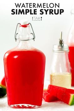 a bottle of watermelon simple syrup next to slices of watermelon and lime