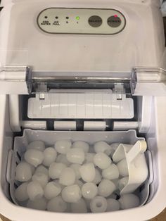 an image of a machine that is filled with white balls and plastic containers in it