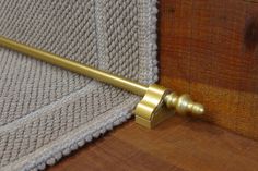 a close up of a door handle on a wooden door with a rug in the background