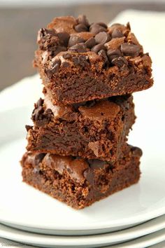 three pieces of chocolate brownies stacked on top of each other in front of the camera