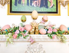 a mantel decorated with flowers, eggs and an easter bunny sitting on top of it