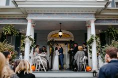 a couple getting married at the end of their wedding ceremony in front of a house