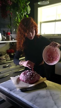 a woman in black shirt preparing food on top of a kitchen counter with utensils