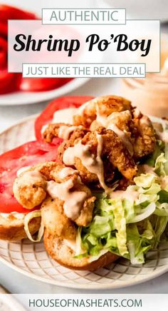 shrimp po'boy with lettuce, tomatoes and sauce on a white plate