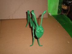 a green toy insect sitting on top of a cardboard box