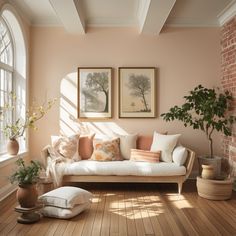 a living room with pink walls and wood flooring, two framed pictures on the wall