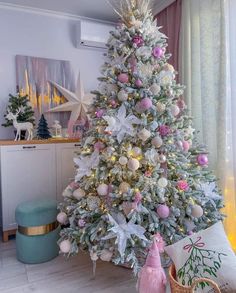 a white christmas tree with pink and silver ornaments