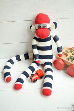 a sock monkey sitting next to a toy truck