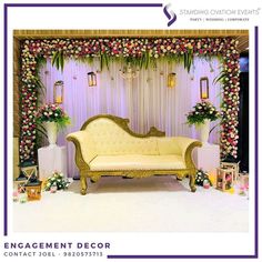 a couch sitting in front of a wall with flowers and greenery on the walls