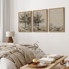 a bed room with a neatly made bed and two pictures on the wall above it