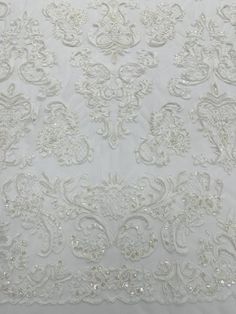 an embroidered white fabric with beads and sequins