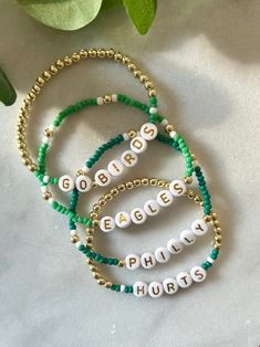 - Calling all Philly football fans! Personalize your custom eagles bracelet for game day. Choose from seed bead with 18k gold accents or a full gold beaded beaded with green accents. Gold filled beads are much more tarnish resistant and long lasting, opposed the the more commonly seen gold plated. These bracelets layer well with others so add this to your stack for your next tailgate! Beaded on high quality stretch cord and secured. - Listing is for (1) bracelet or set of (2). Set includes (1) g Customizable Sports Team Color Jewelry For Events, Team Spirit Round Beads Jewelry For Game Day, Adjustable Gold Beaded Bracelets For Game Day, Football Beaded Bracelets, Personalized School Spirit Jewelry For Game Day, Team Spirit Beaded Bracelets For Game Day, Customizable Team Spirit Jewelry For Game Day, School Spirit Personalized Jewelry For Game Day, Eagles Bracelet