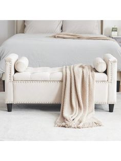 a white bed with pillows and blankets on it